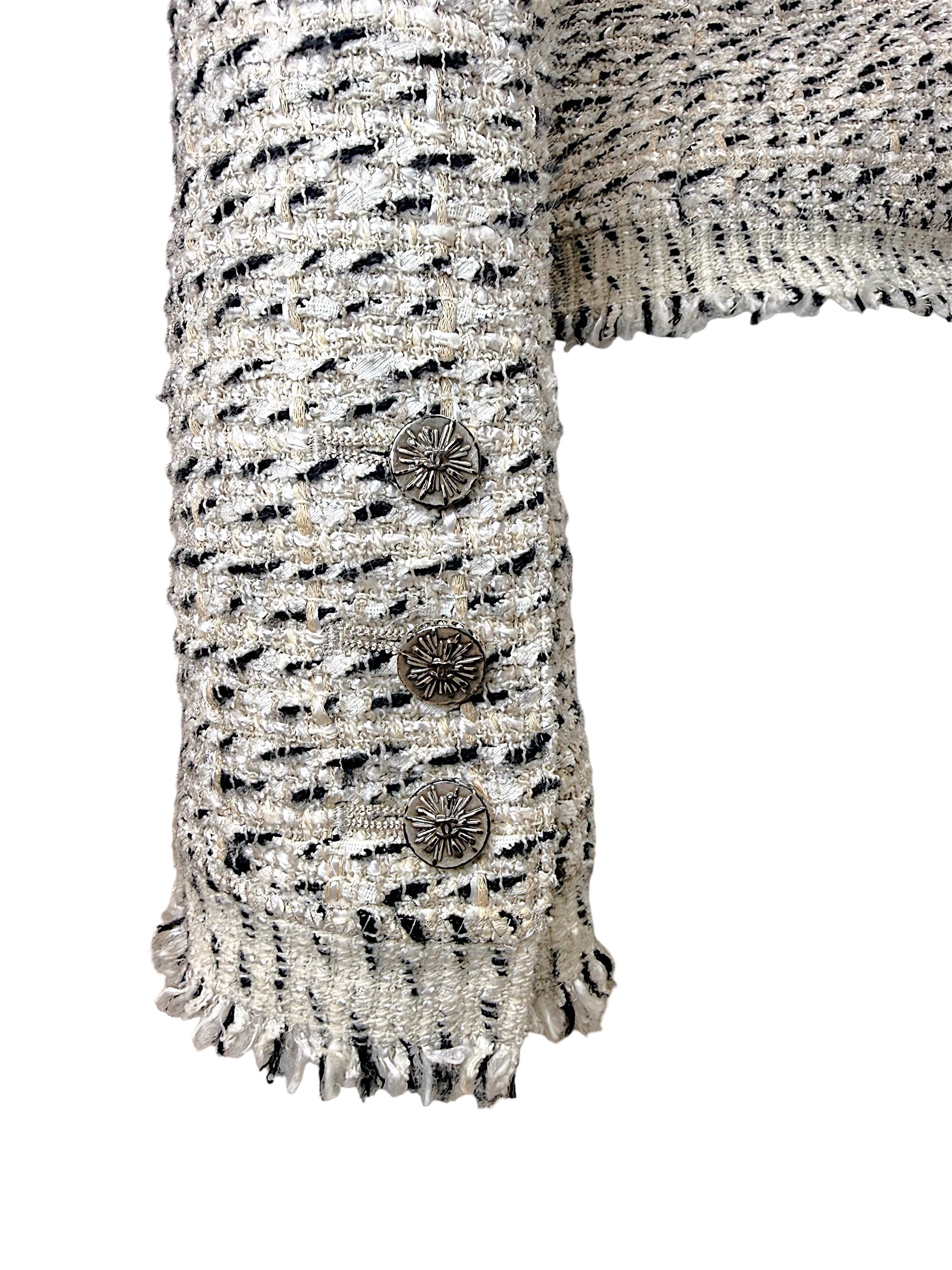 Close-up of Chanel logo sleeve buttons and fringe cuff detail on 2004 Lesage tweed jacket