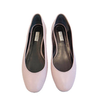 Top view of powder pink Balenciaga lambskin flats showing the rounded vamp and black leather interior with Balenciaga logo.