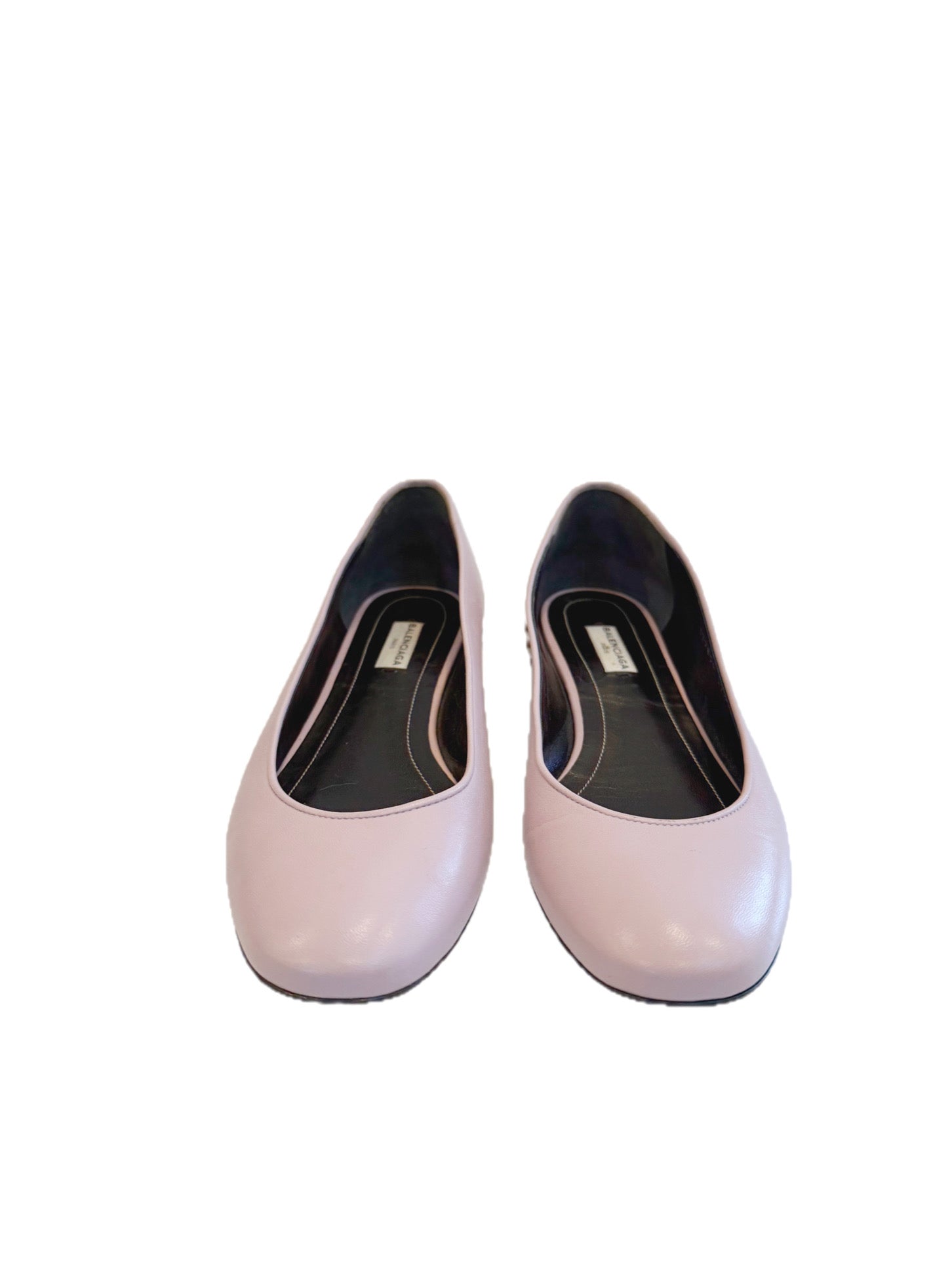 Front angle of Balenciaga powder pink lambskin ballet flats featuring rounded toes and smooth leather finish on a clean white background.