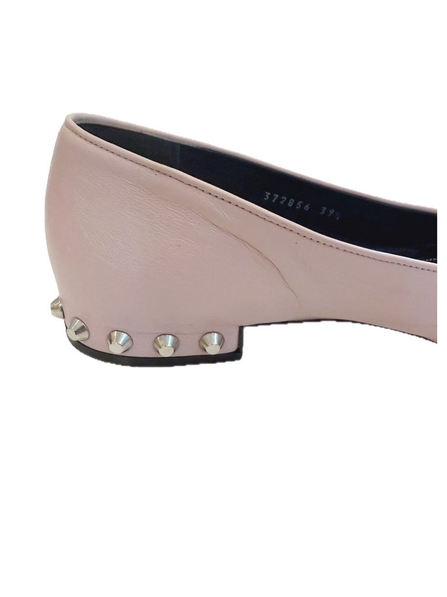 Close-up side view of Balenciaga powder pink lambskin flat showing silver cone studs along the sculpted low heel.
