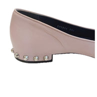 Close-up side view of Balenciaga powder pink lambskin flat showing silver cone studs along the sculpted low heel.