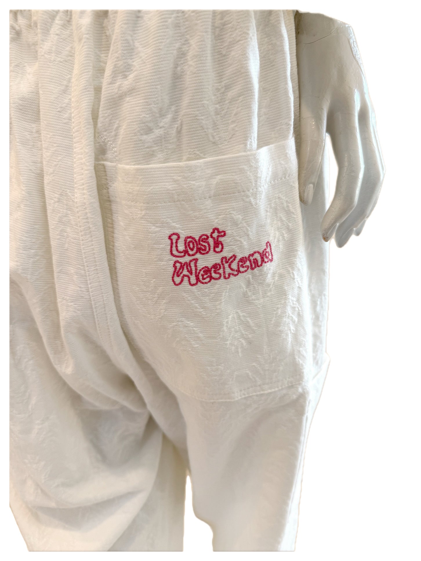Close-up of pink “Lost Weekend” embroidery on the back pocket of the SS20 Bernhard Willhelm jumpsuit.