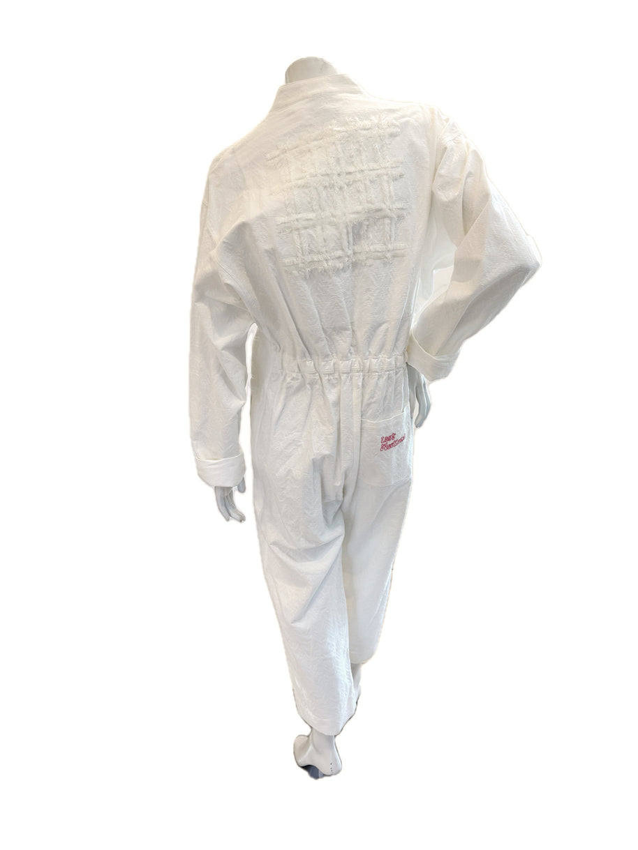 Back view of SS20 “Lost Weekend” jumpsuit featuring lattice appliqué and pink embroidered back pocket.