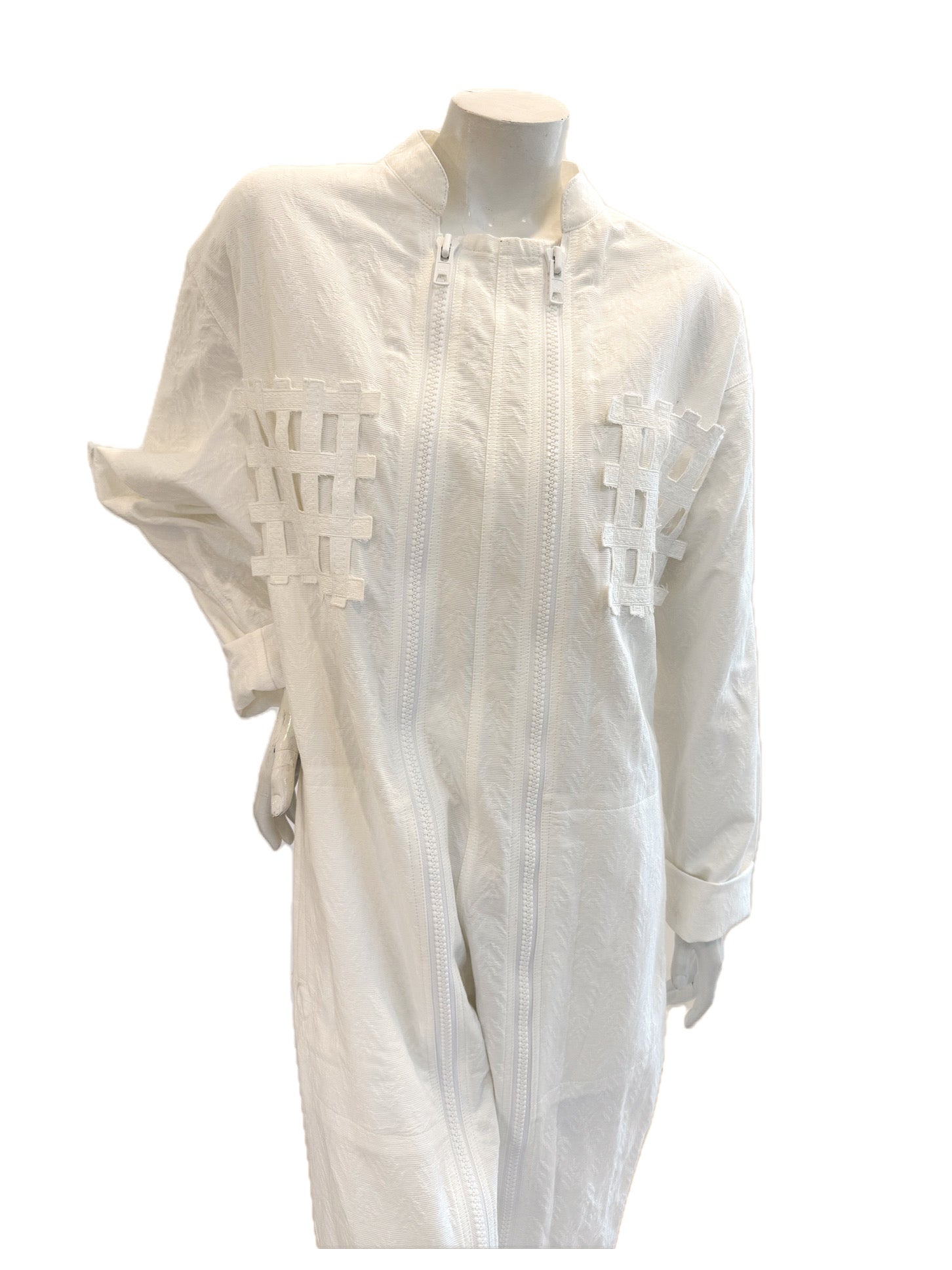 Close-up of chest showing lattice appliqué and dual zipper design on Bernhard Willhelm SS20 white jacquard jumpsuit.