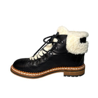 Chanel Quilted Leather Black hiking boot with white shearling lining inner view of right shoe on a white background 