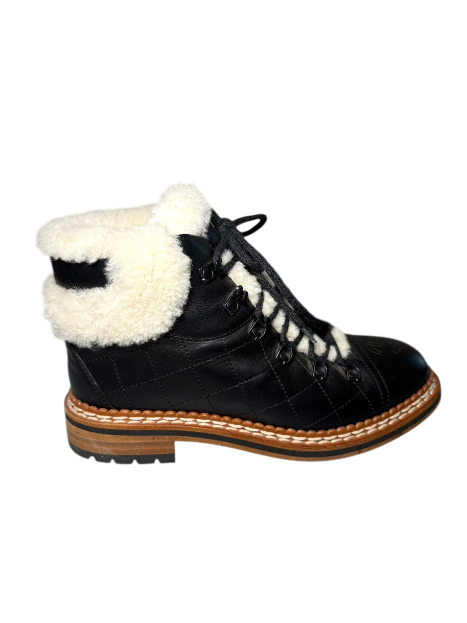 Chanel Quilted Black Leather boot with white shearling lining right shoe side view on a white background