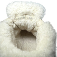 Chanel Black Quilted Shearling Hiking Boots Close-up of shearling lining with a visible product label and size of 38.5 on a white background