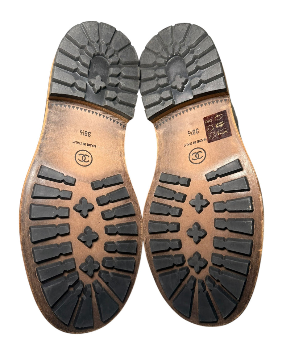 Chanel Quilted Black Shearling Hiking Boots Size 38.5 Close-up of brown leather shoe soles with a white background