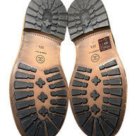 Chanel Quilted Black Shearling Hiking Boots Size 38.5 Close-up of brown leather shoe soles with a white background