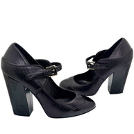 Side view of Chanel Mary Jane block heel pumps in black leather with adjustable strap and patent toe detail.