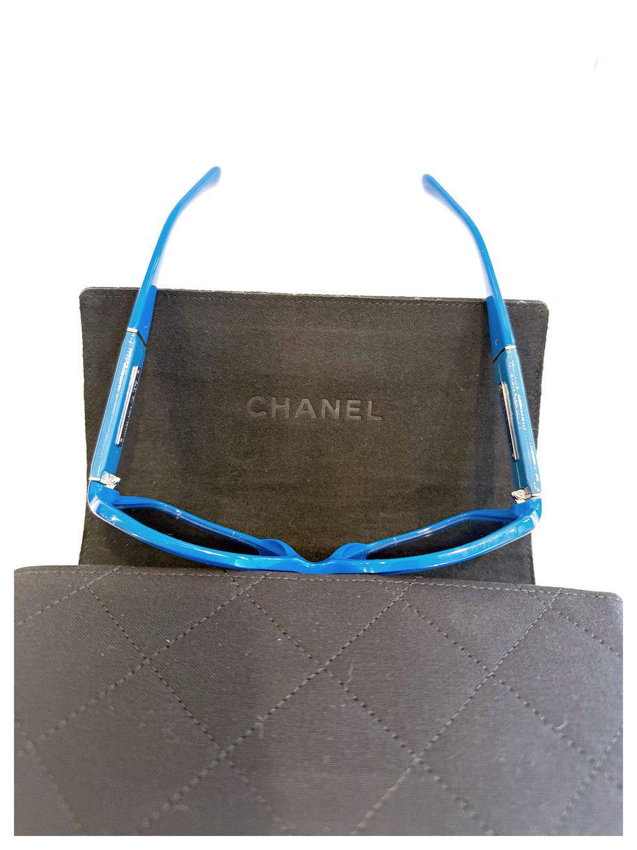 Interior view of Chanel blue sunglasses with CHANEL logo visible inside black case.
