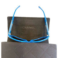 Interior view of Chanel blue sunglasses with CHANEL logo visible inside black case.