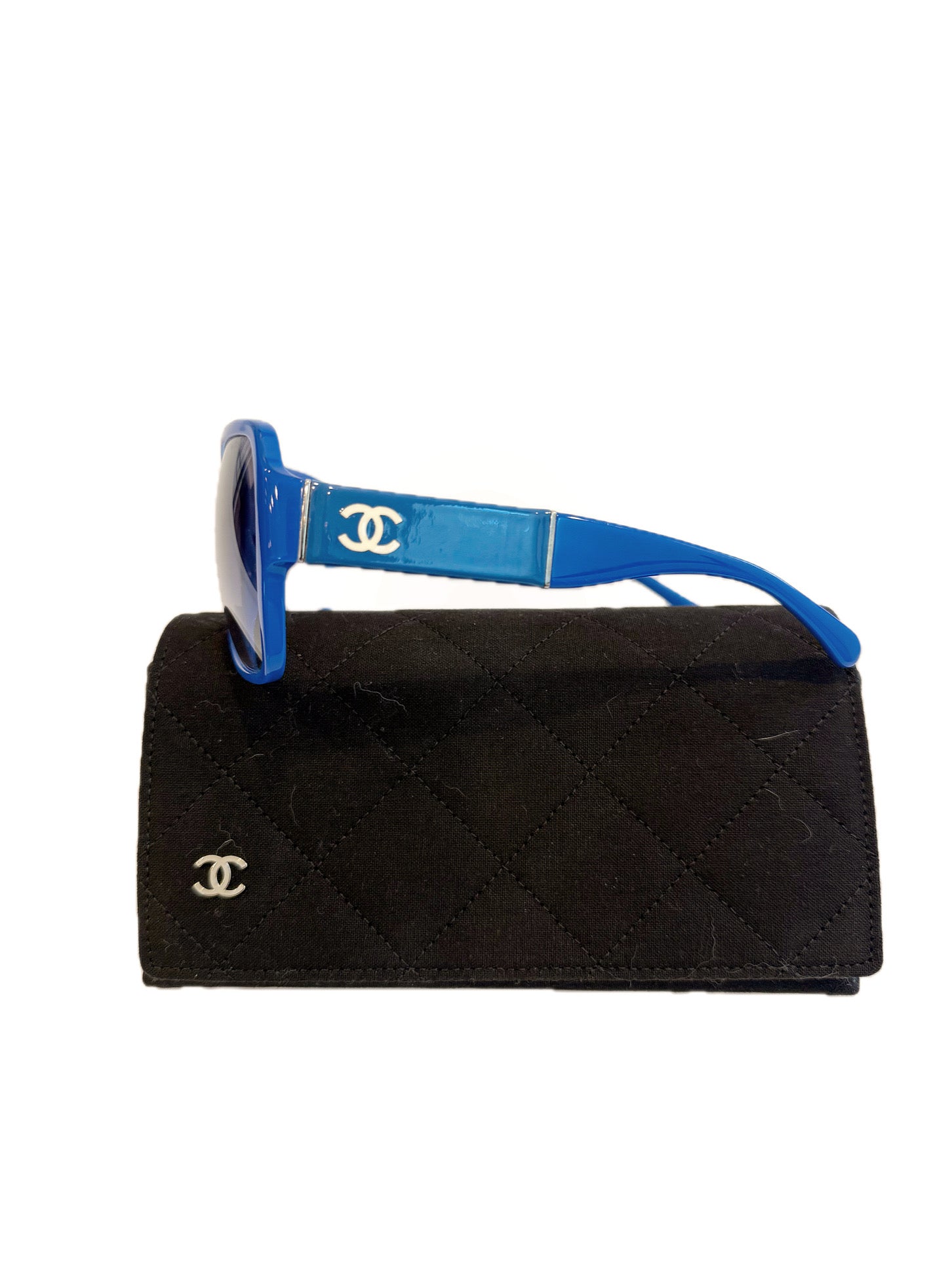 Chanel blue sunglasses left side showing white CC logo and thick acetate temple on case.