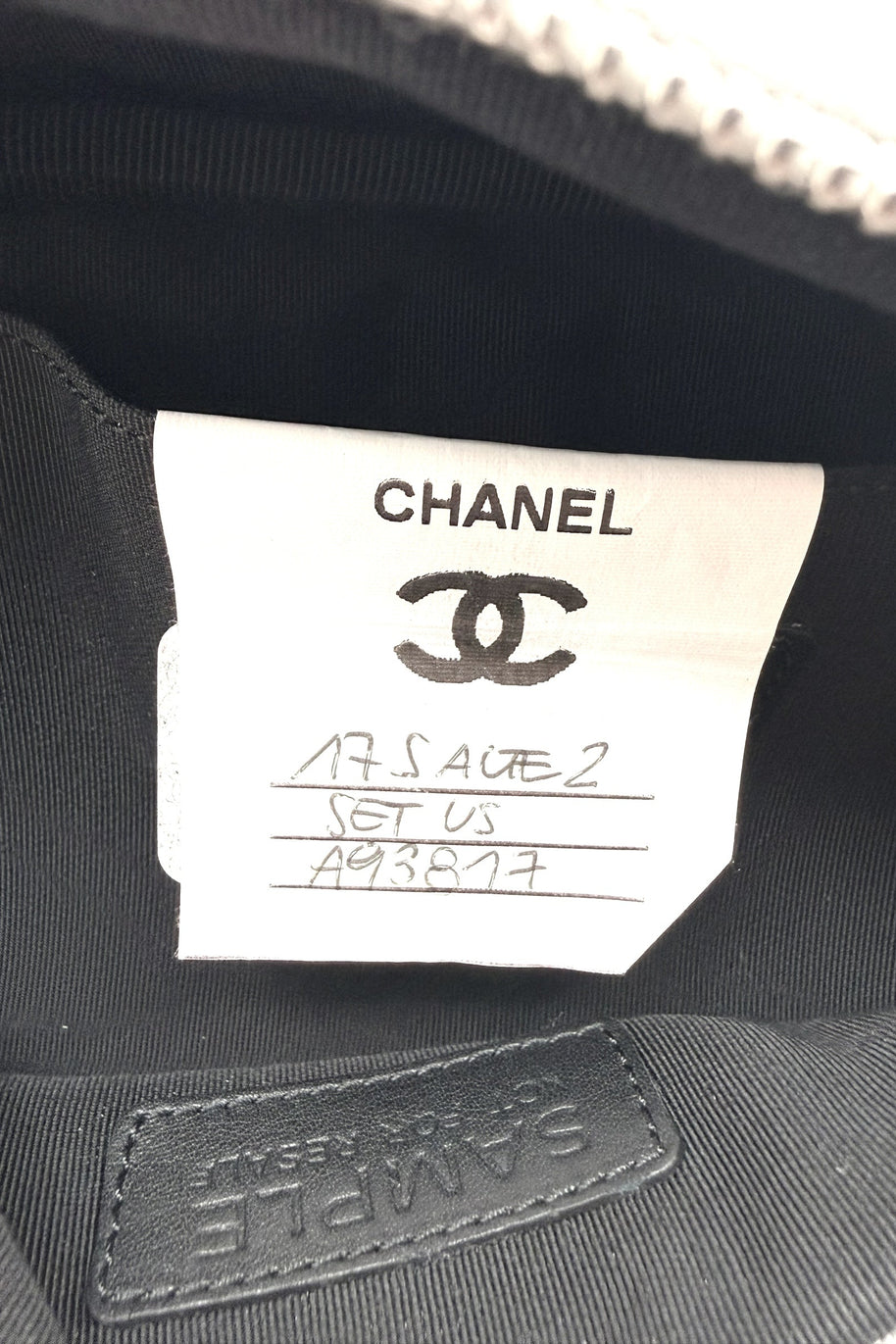 Interior close up of Chanel metallic silver bum bag showing sample label stitched into black lining, indicating production reference detail.