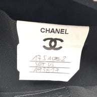 Interior close up of Chanel metallic silver bum bag showing sample label stitched into black lining, indicating production reference detail.