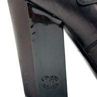 Chanel block heel detail with embossed CC logo on black leather Mary Jane pump.