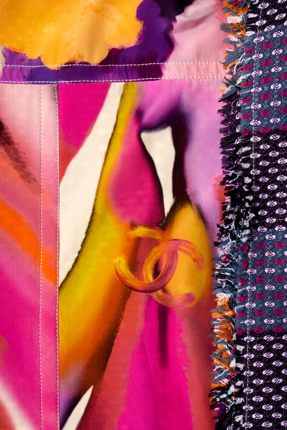 Close-up of Chanel colorful fabric with floral patterns and vibrant colors and iconic interlocking C's logo with tweed coat border.