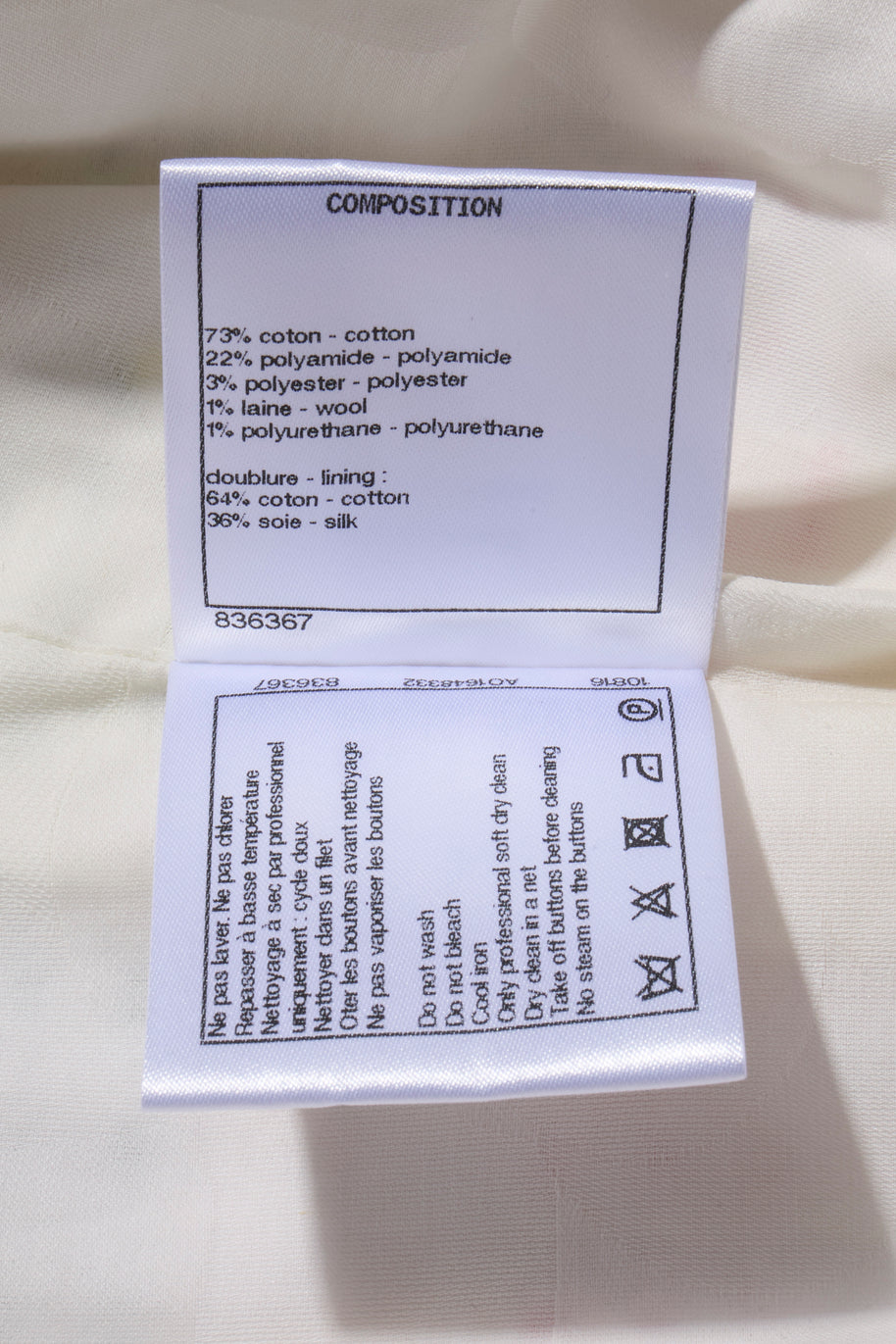 Chanel Fabric composition label on a white background attached to Spring 2019 Rainbow Striped Coat