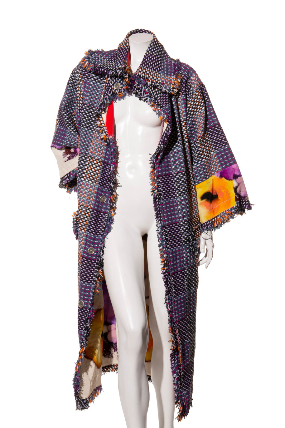 Mannequin wearing a colorful Chanel tweed patterned coat with floral designs on the interior and sleeves on a white background