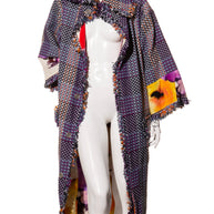 Mannequin wearing a colorful Chanel tweed patterned coat with floral designs on the interior and sleeves on a white background