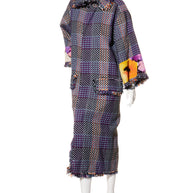 Chanel tweed coat with floral accents on a mannequin against a white background giving a left angle view