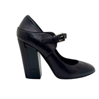 Single Chanel Mary Jane pump in black and brown leather showing block heel profile and rounded toe silhouette.