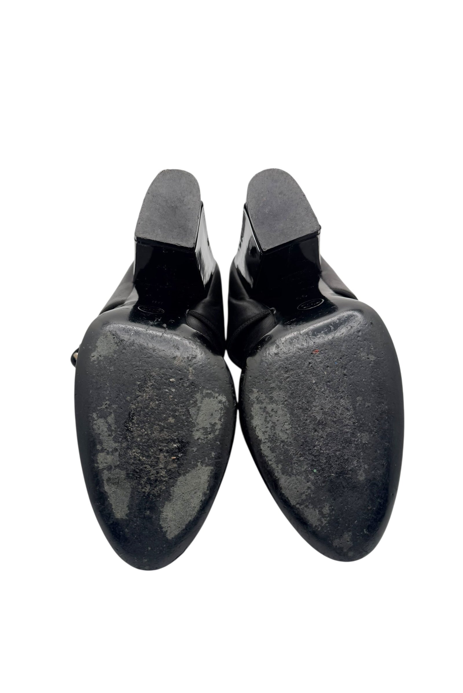 Bottom view of Chanel Mary Jane pumps showing leather soles with visible wear.