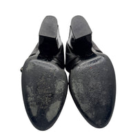 Bottom view of Chanel Mary Jane pumps showing leather soles with visible wear.