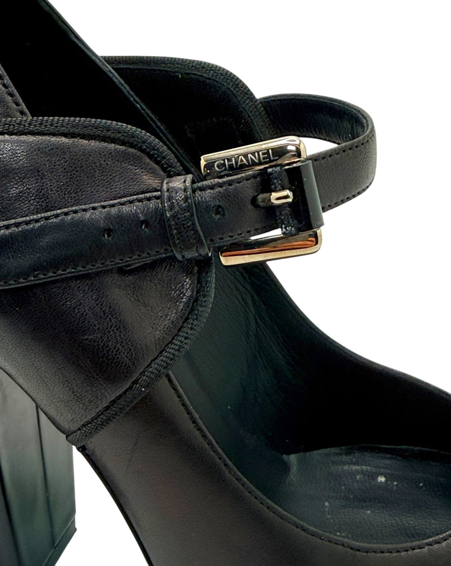 Close-up of Chanel Mary Jane strap with silver-tone buckle on black and brown leather pump.