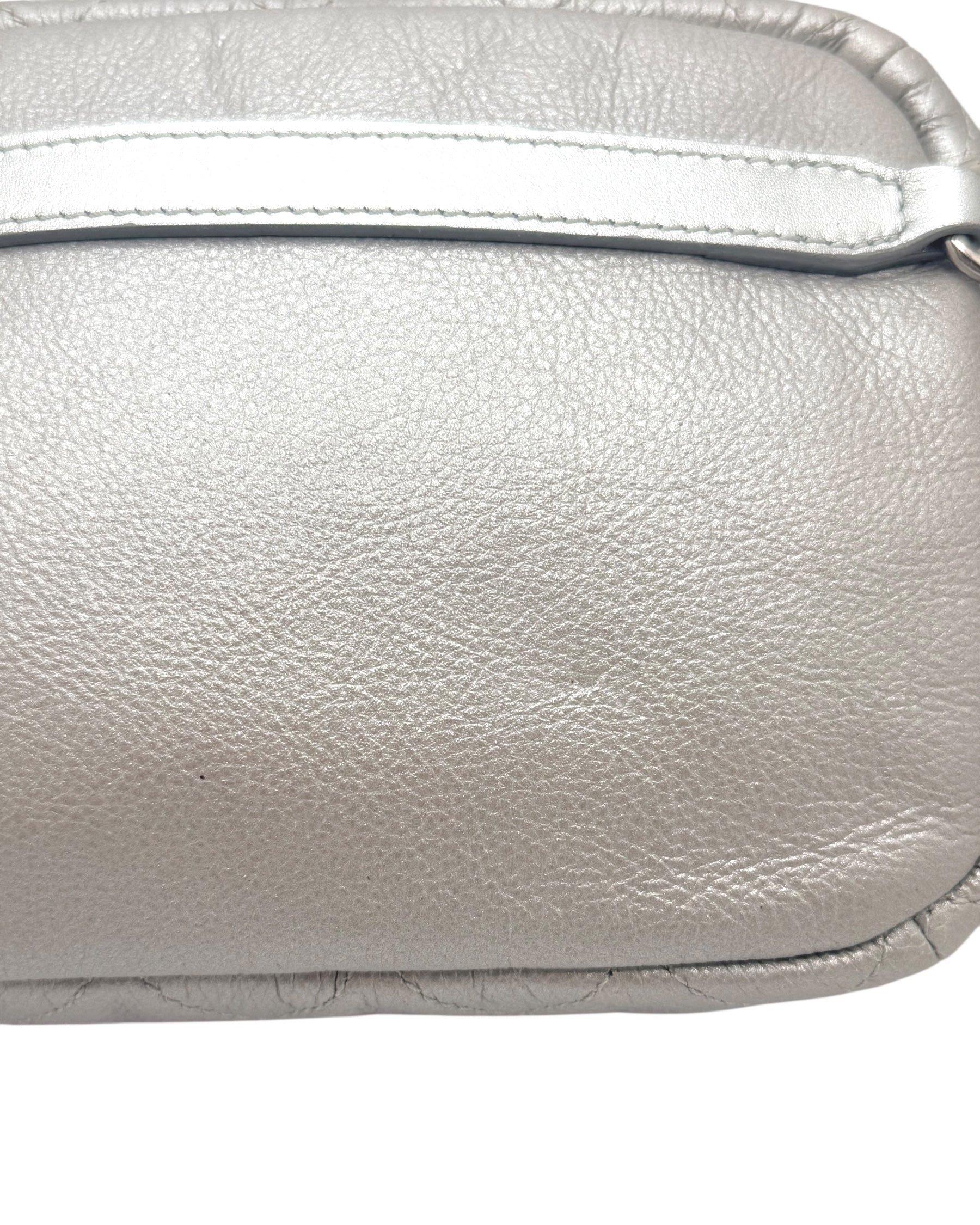 Close up view of Chanel SS17 metallic silver leather bum bag highlighting natural grain texture, stitching, and smooth leather panel detail.