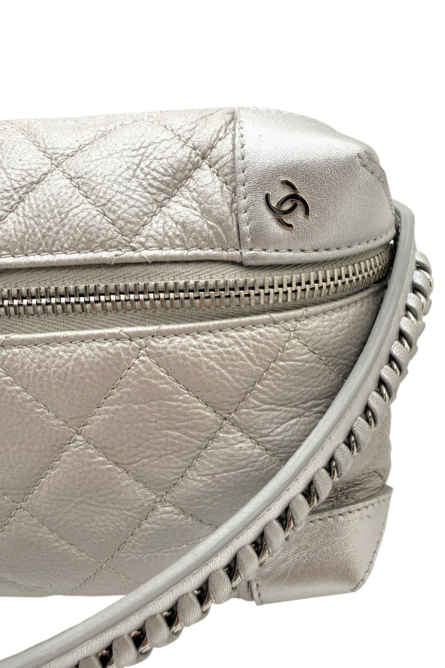 Close up of Chanel metallic silver quilted bum bag strap showing leather woven chain construction and refined stitching.