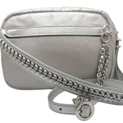 Close up of Chanel metallic silver bum bag showing leather interwoven chain strap detail and luxury hardware finish.
