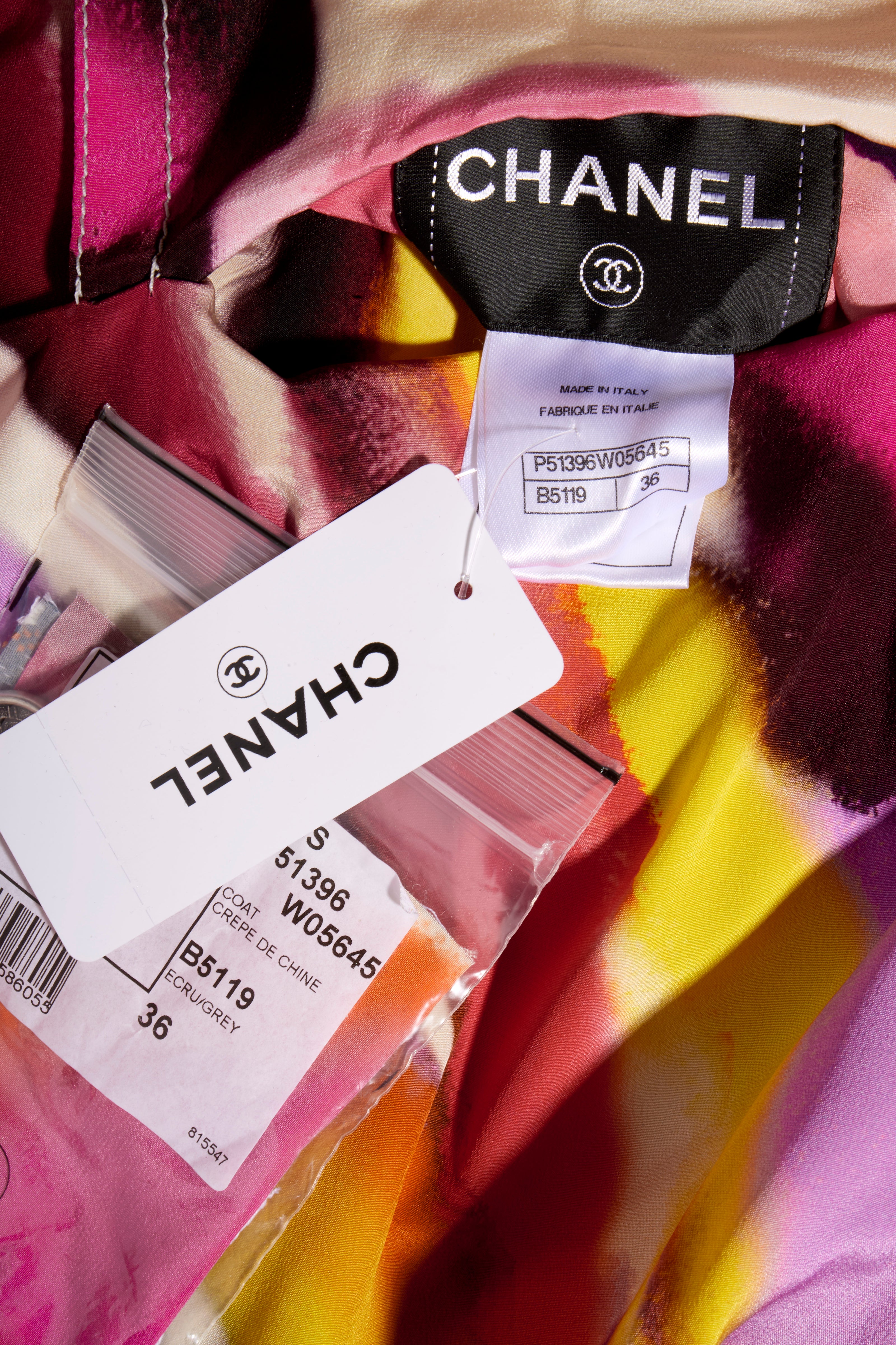 Close-up of Chanel clothing label with Chanel retail tags attached to the tweed reversible coat bright floral pattern side