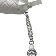 Close up of Chanel metallic silver bum bag showing leather interwoven chain strap detail and luxury hardware finish.