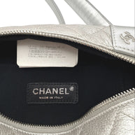 Close up of interior Chanel bum bag showing branded care tag, season marking, and authenticity identifiers inside black fabric lining.