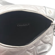 Interior view of Chanel metallic silver quilted bum bag showing Chanel Made in Italy leather label and black fabric lining.