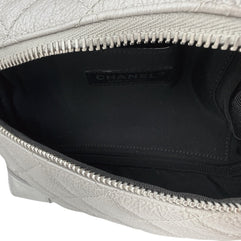 Wide interior view of Chanel metallic silver quilted bum bag showing spacious compartment, zip opening, and black fabric lining.