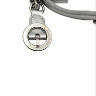 Close up of Chanel metallic silver bum bag showing engraved Rue Cambon Paris circular hardware charm with leather and chain strap attachment.