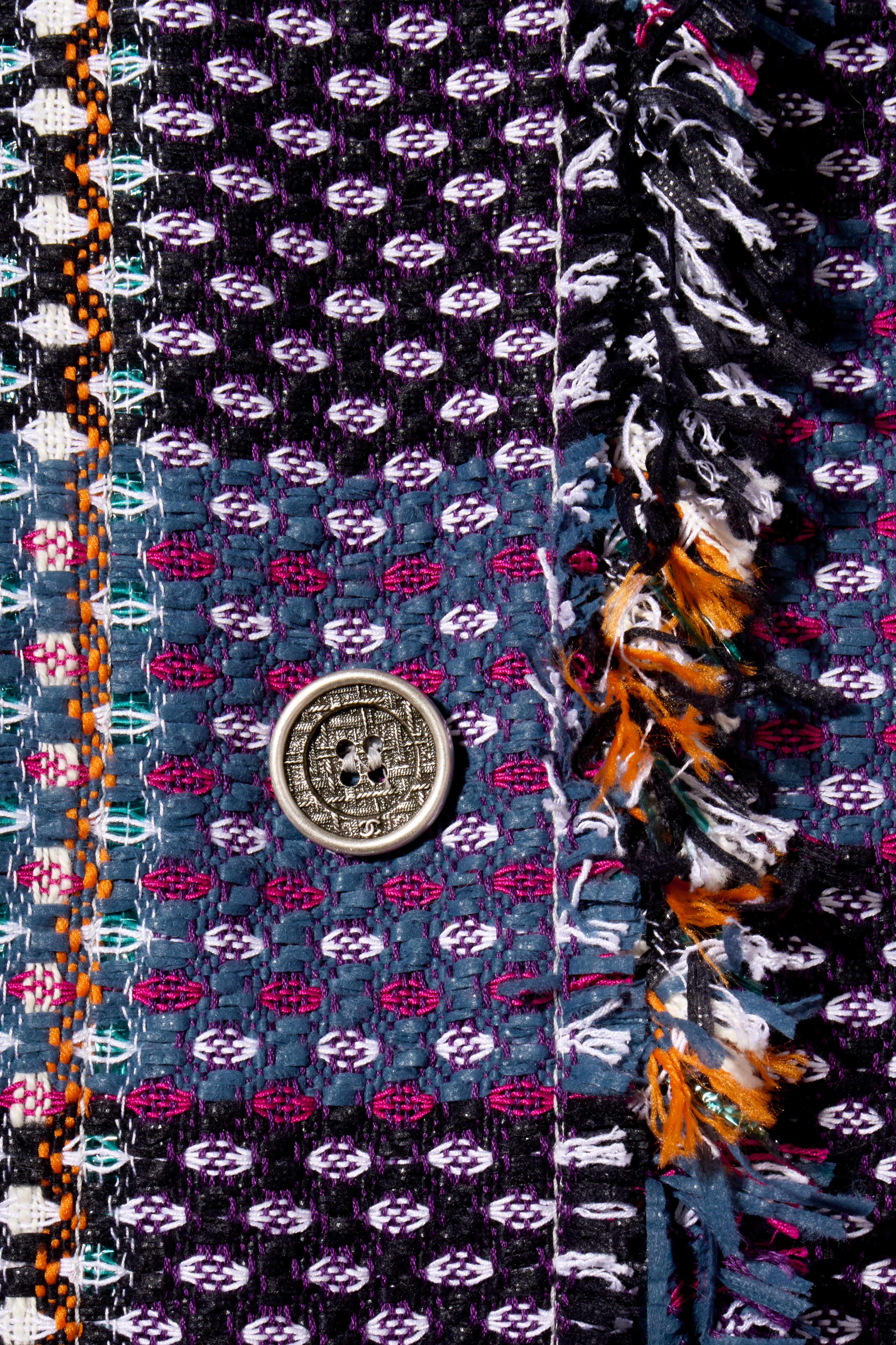 Close-up of Chanel Tweed Coat Button and fringe detail decorative elements