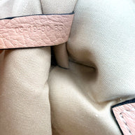 Close-up of interior authenticity date code stamp on leather tag inside Chloé Alphabet blush leather pouch.