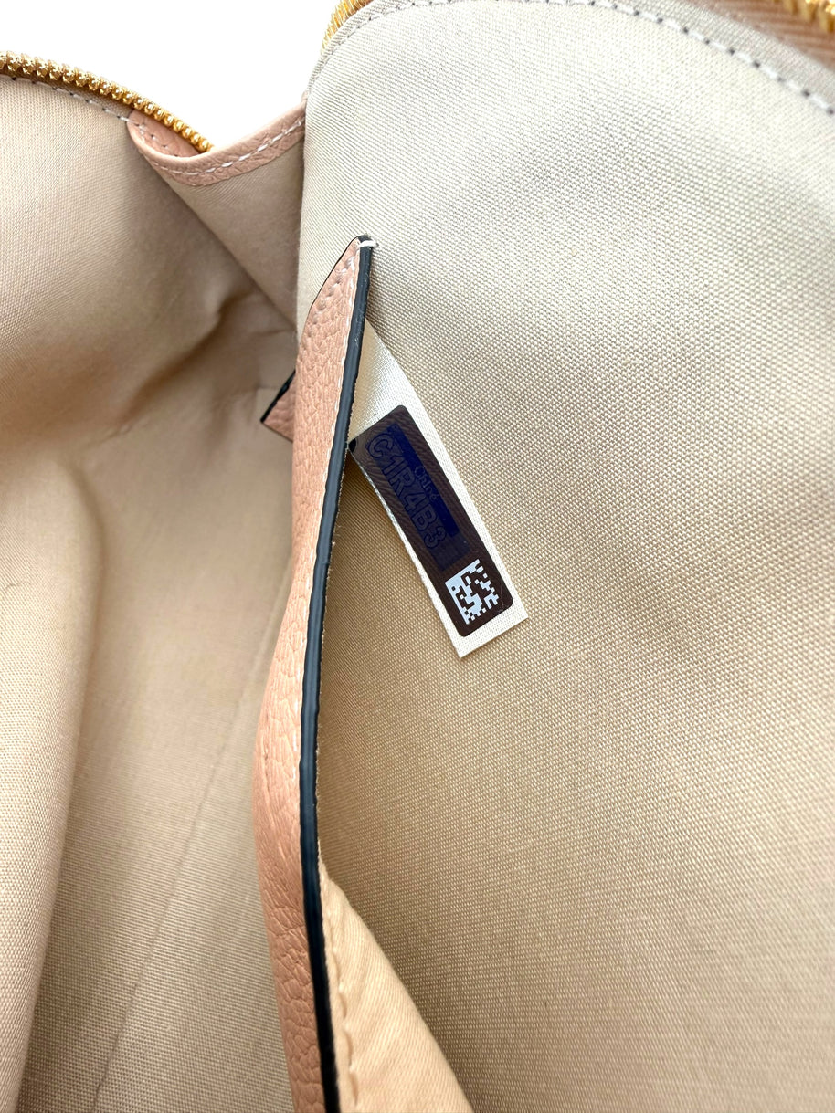 Close-up of interior authenticity hologram tag inside Chloé Alphabet blush leather pouch.