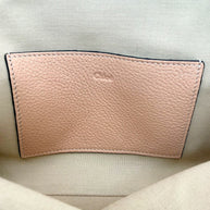 Interior of Chloé Alphabet blush leather pouch showing slip pocket with embossed Chloé logo on canvas lining.