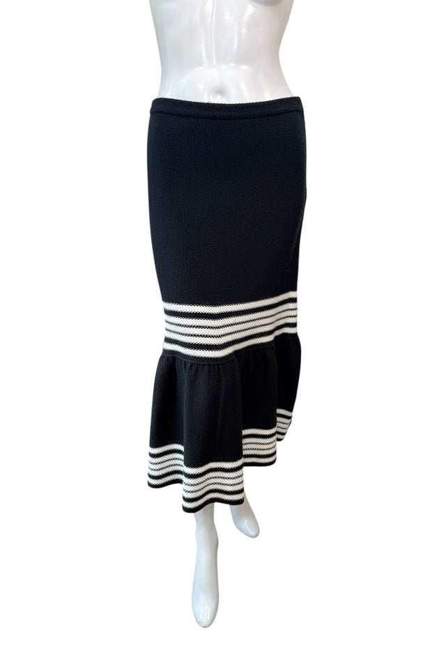 Front view of Christian Dior black knit fluted midi skirt featuring high-waisted fitted silhouette and ivory stripe detailing at the hem.