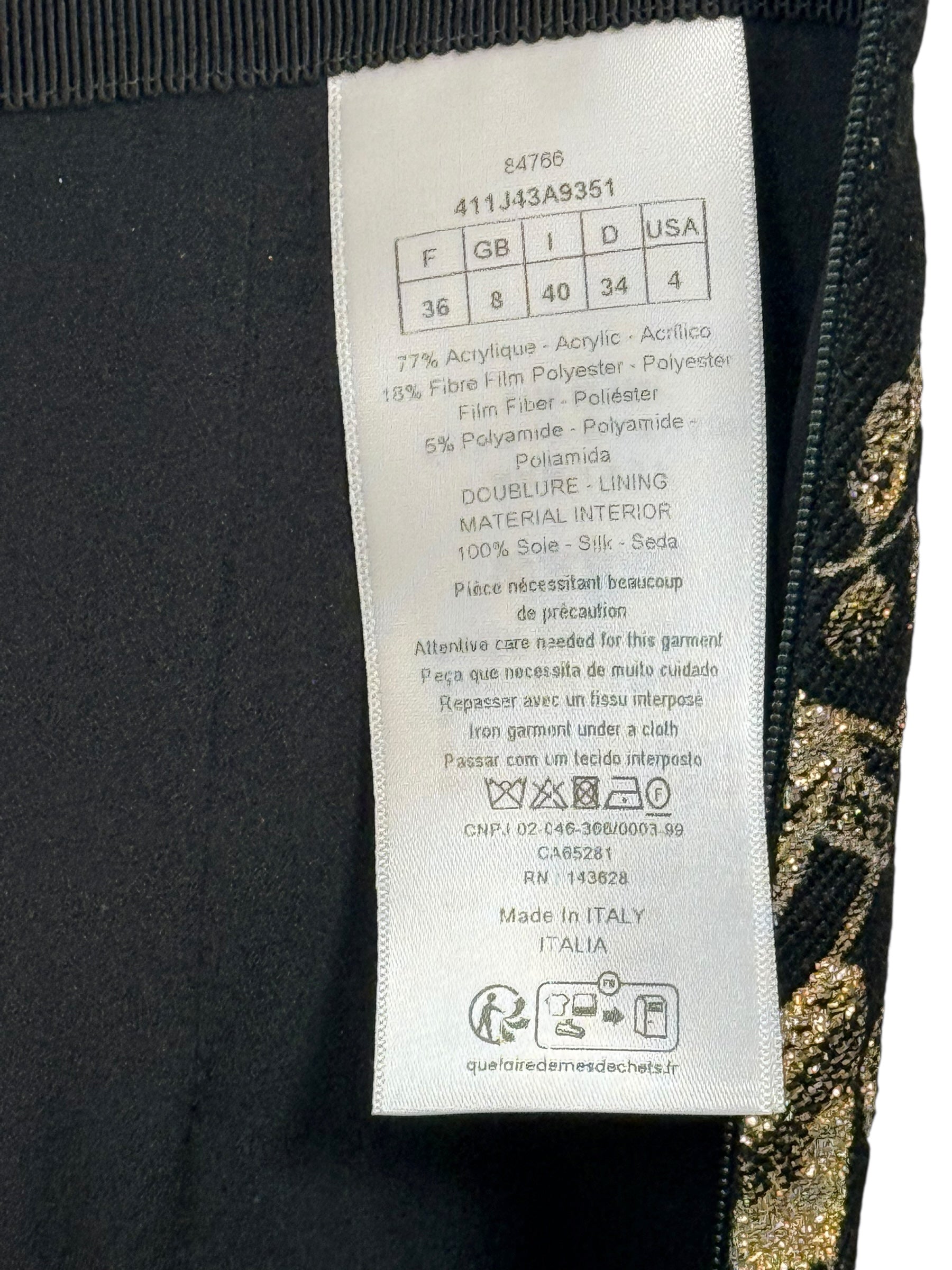 Close-up of Christian Dior skirt care label showing size FR 36 US 4 and metallic jacquard fabric composition.