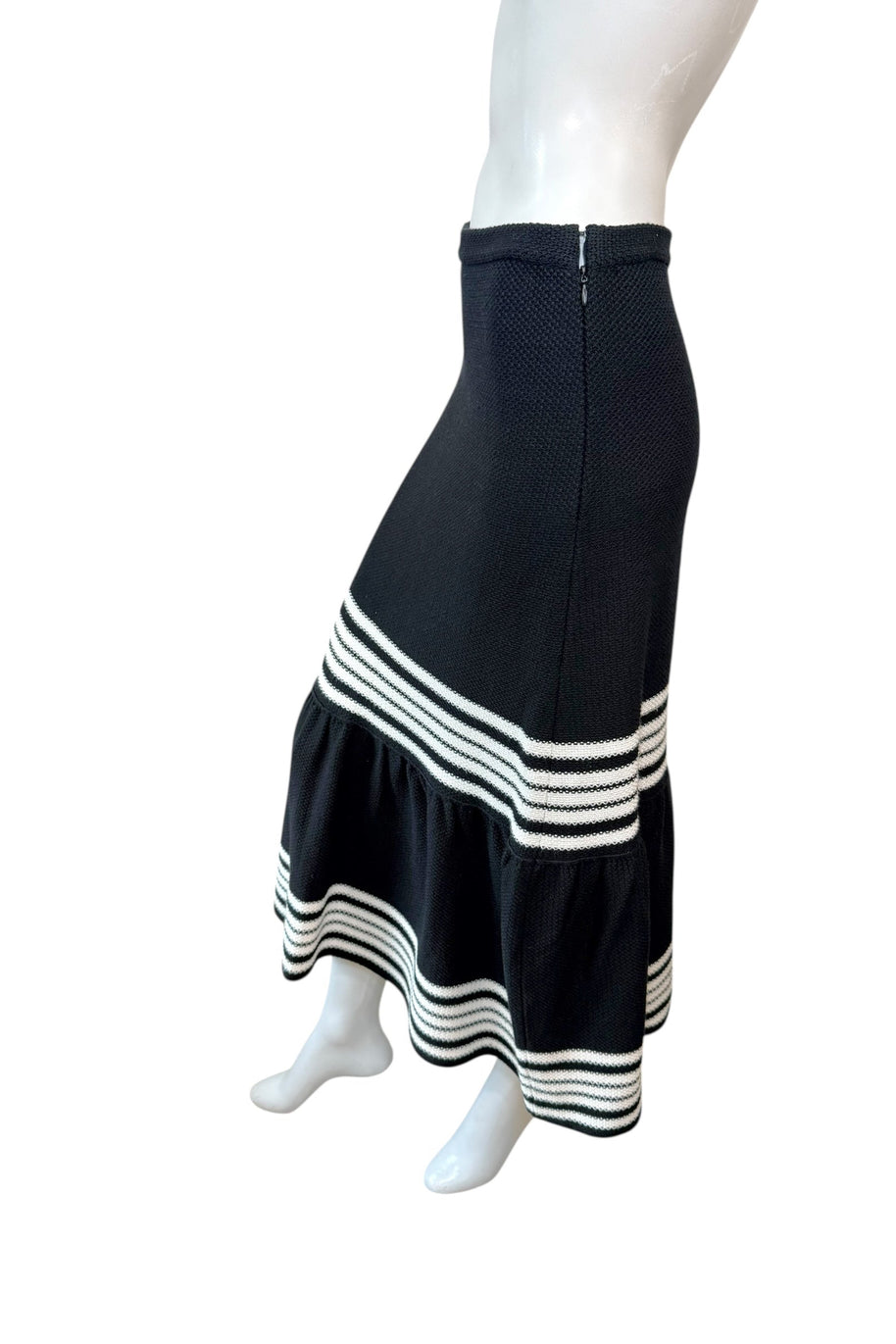Side view of Christian Dior black knit midi skirt showing fluted mermaid hem and textured knit construction.
