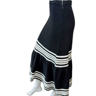 Side view of Christian Dior black knit midi skirt showing fluted mermaid hem and textured knit construction.
