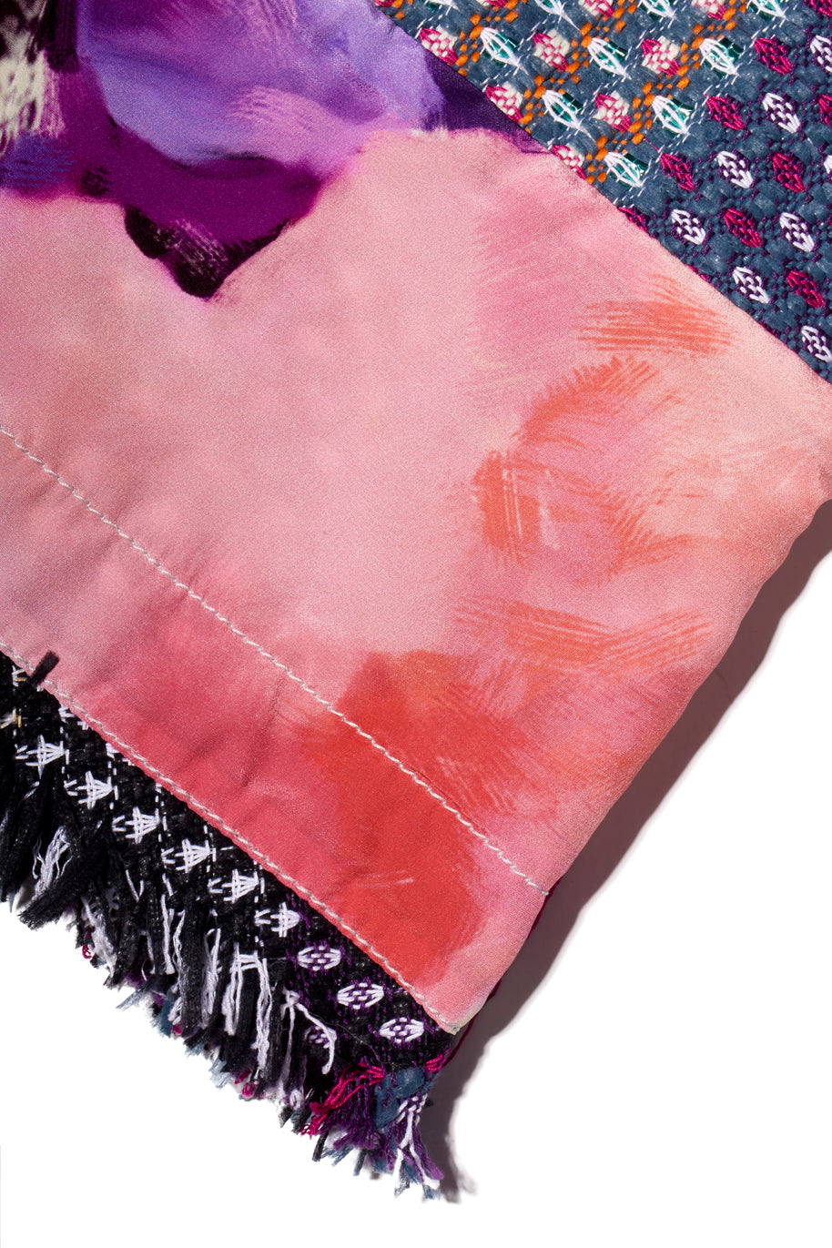 Chanel Close-up of a pink fabric with multi-color purple, pink, blue, black and white fringe on a white background