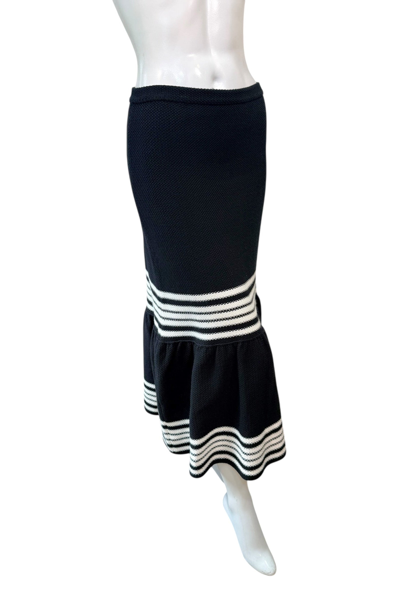 Angled view of Dior black knit midi skirt with fluted hem and contrasting ivory stripe band.