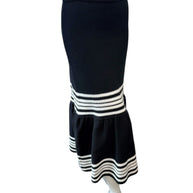 Angled view of Dior black knit midi skirt with fluted hem and contrasting ivory stripe band.