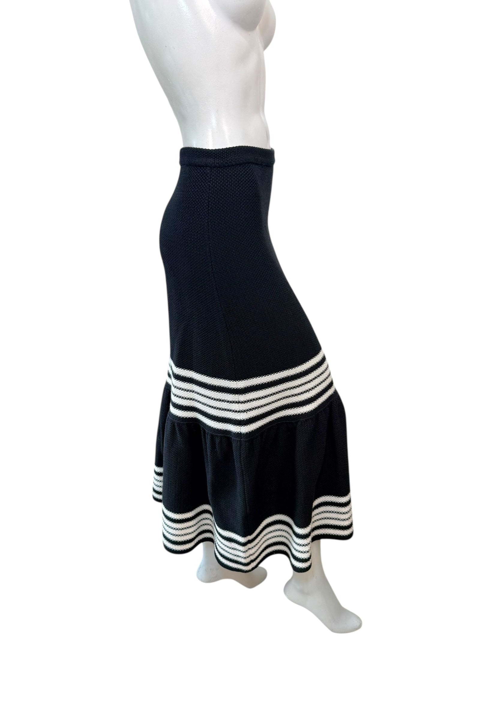 Profile angle of Christian Dior knit midi skirt emphasizing high waist, structured fit, and flared hem movement.